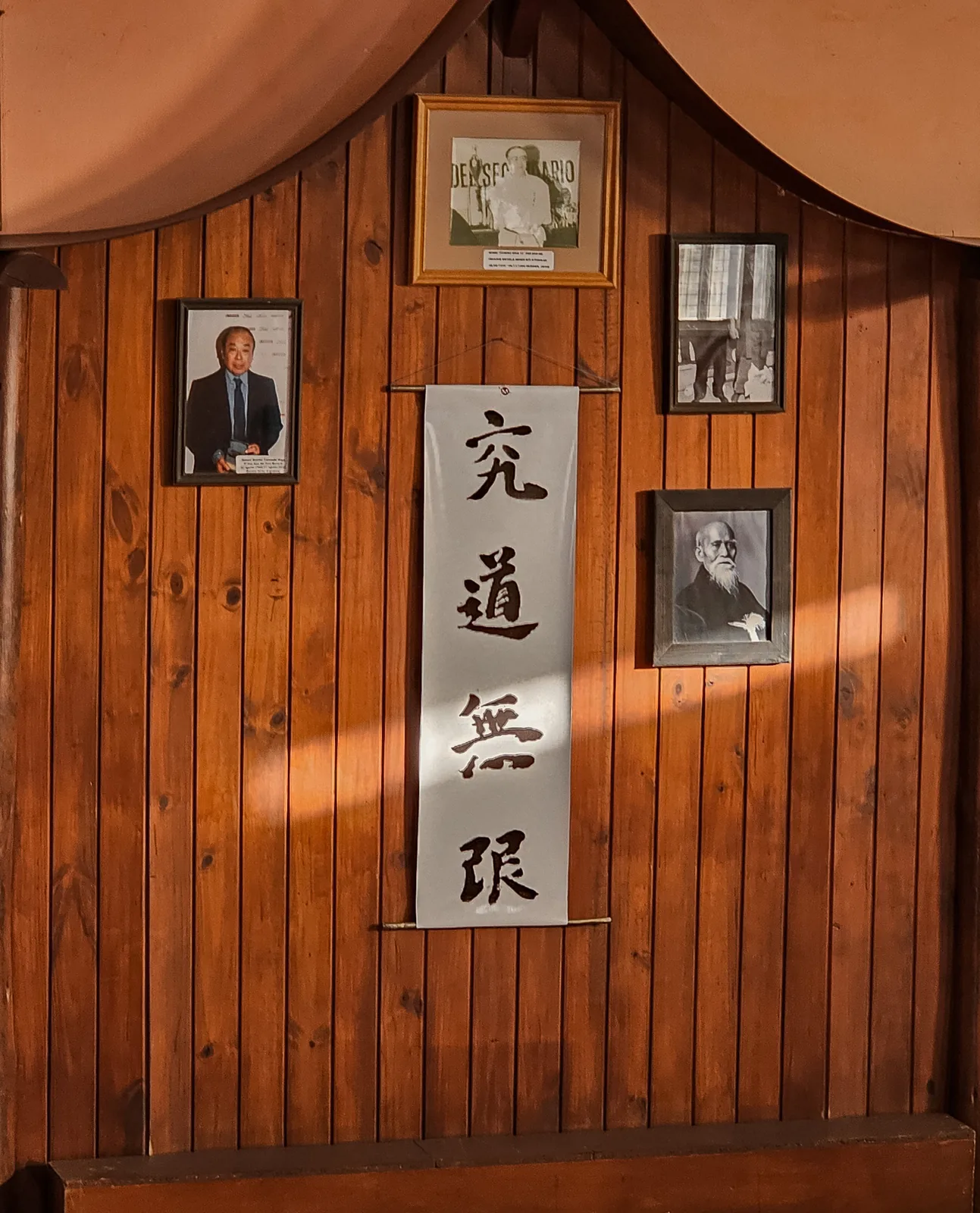 Kamiza del dojo con retratos y caligrafía japonesa.